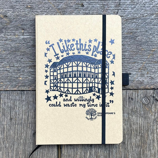Notebook with a black illustration and text on a wooden surface