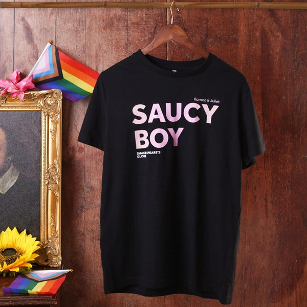 Black t-shirt with 'SAUCY BOY' text on a wooden wall background