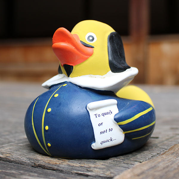Rubber duck with a humorous message on a wooden surface