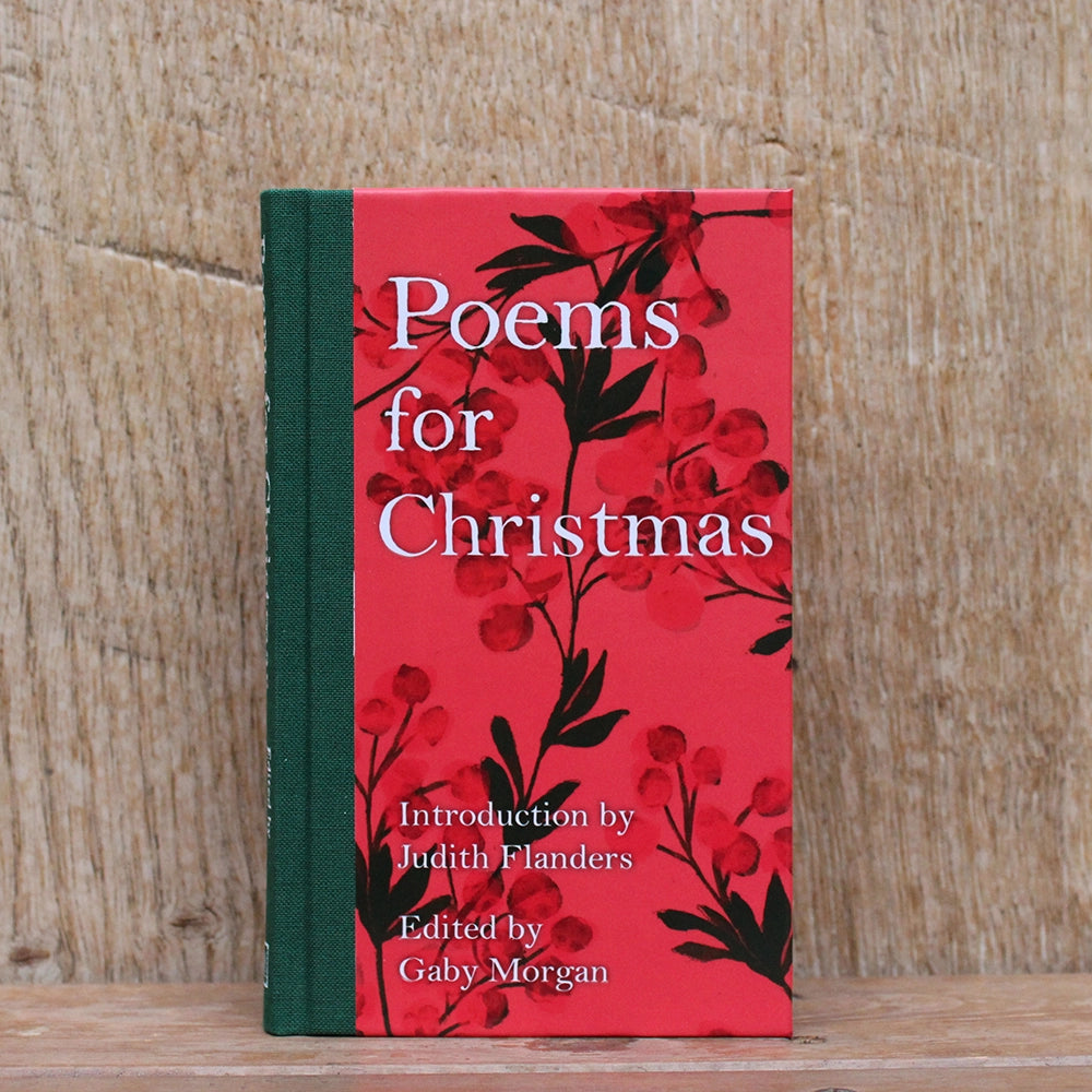 Red hardback book with green spine and white text, featuring red Christmas greenery images