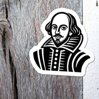A die-cut sticker featuring a black and white woodcut-style portrait of William Shakespeare, shown against a split background of weathered wood and a white textured wall.