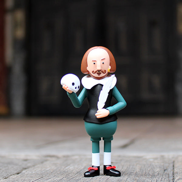 Plastic Shakespeare figurine, holding quill and skull, wearing green outfit, standing on the Globe stage