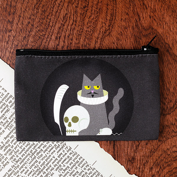 Grey pouch with a cat and skull design on a wooden surface