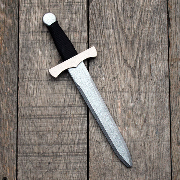 wooden dagger with a silver blade and a black handle on a wooden surface