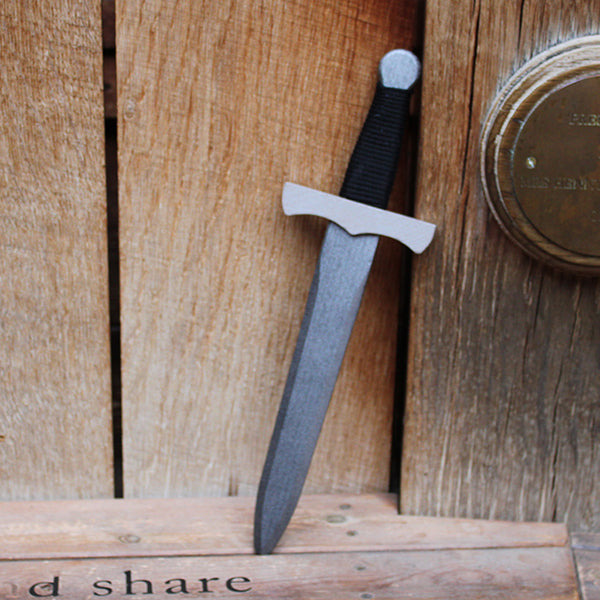 Wooden dagger with a black handle on a wooden surface
