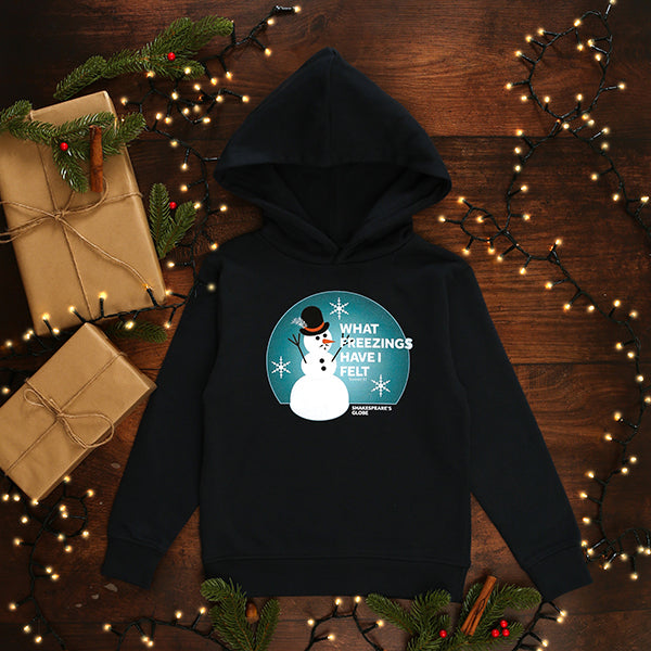 a navy blue children's hoodie with a snowman design on a wooden surface