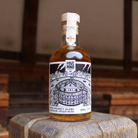glass bottle containing an amber liquid with a black and white label
