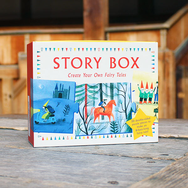 Story Box packaging with illustrations of fairy tale scenes on a wooden surface.