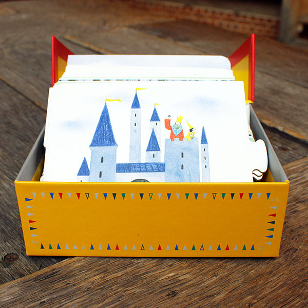 Yellow box with cards featuring castle illustrations on a wooden surface