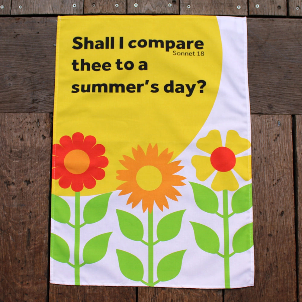 White tea towel printed with a large yellow sun, three stylised flower and a black quote