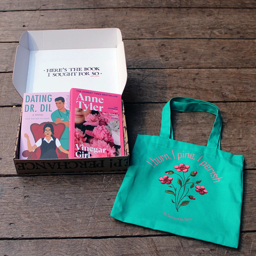 
                      
                        Kraft book box with white interior and exterior printed with black block text, open with 2 pink paperback books inside and teal printed bag lying to the bottom right
                      
                    