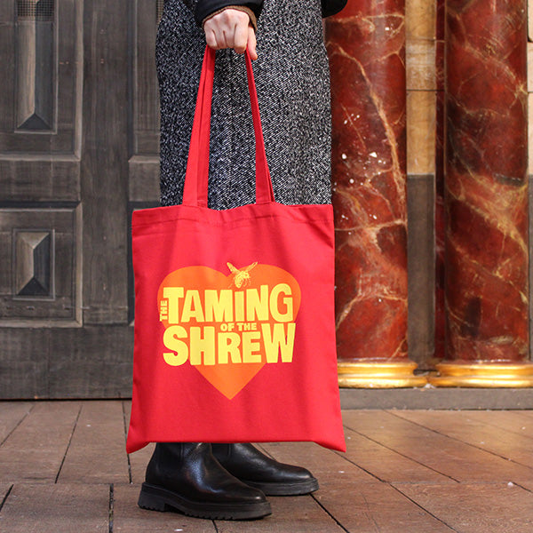 
                  
                    Red cotton tote bag with two handles and orange heart graphic in centre with yellow stylised text and wasp graphic
                  
                