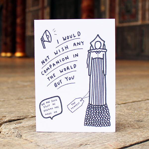 Card with a drawing of a figure and text on a wooden surface