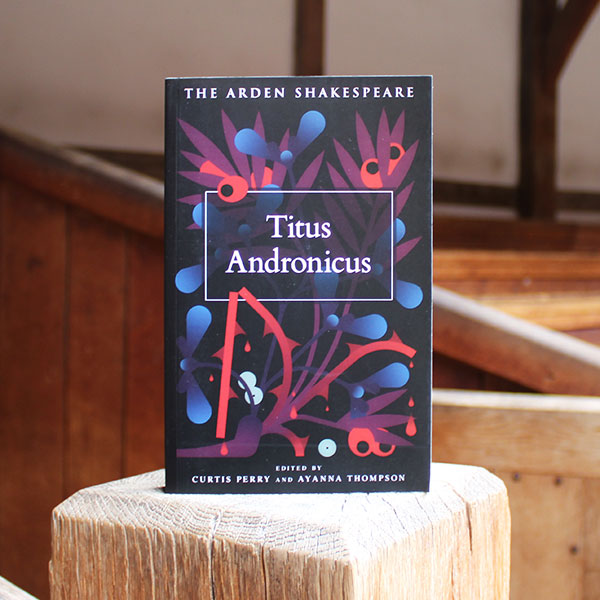 Book titled 'Titus Andronicus' from The Arden Shakespeare series on a wooden surface.