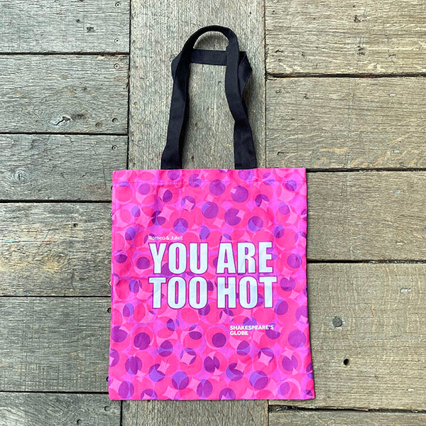 Tote bag with pink and purple pattern and text on a wooden surface