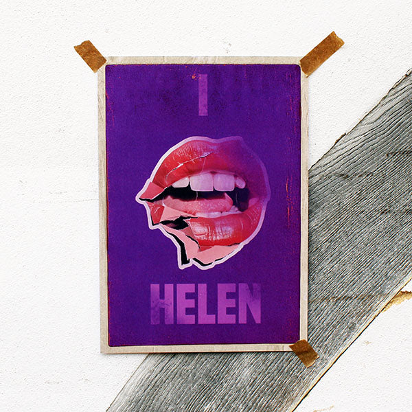 Purple art print with a graphic of lips and the name 'HELEN' on a wooden surface.