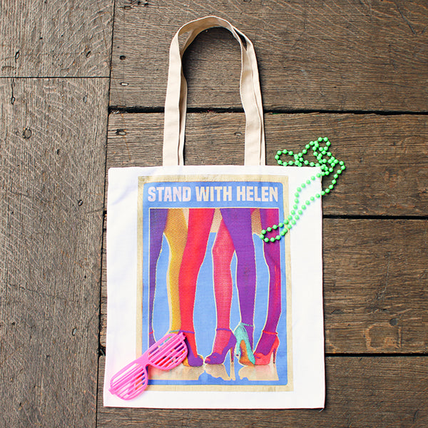 Tote bag with 'Stand With Helen' design on a wooden surface