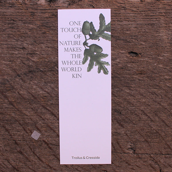 White hard card bookmark with olive green text and depiction of acorns and leaves