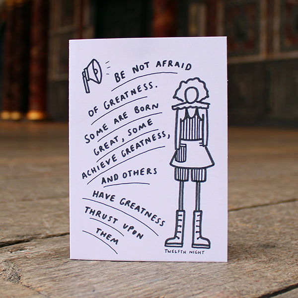 White greetings card with text and an illustration on a wooden surface