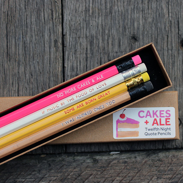 Four quote stamped pencils from top to bottom: pink, white, yellow, gold, sitting on a kraft box with white sticker