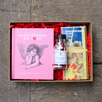 Gift set with books and a bottle labeled 'Shakespeare & Love' on a wooden surface