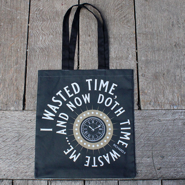 
                      
                        Grey cotton tote bag with two darker grey handles and gold clock with white circular text surrounding
                      
                    