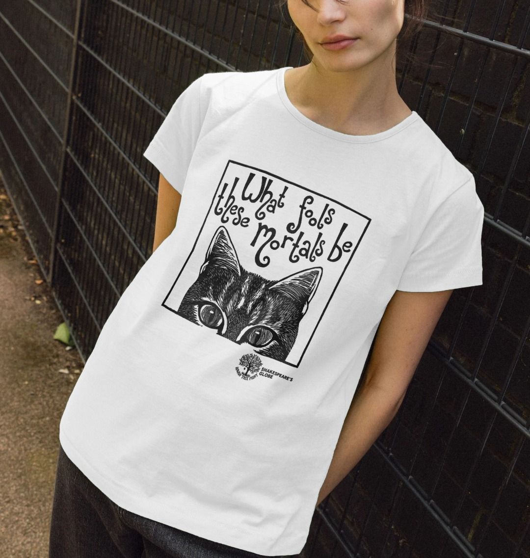 Person wearing a white t-shirt with a black cat graphic and text against a dark wall.