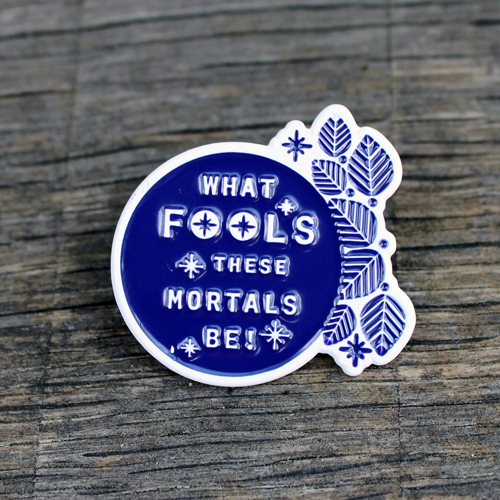 White pin badge with blue filling, white text and blue leaves