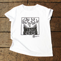 White t-shirt with a black cat illustration and text on a wooden surface