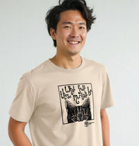 Man wearing a beige t-shirt with a black graphic design on a plain background