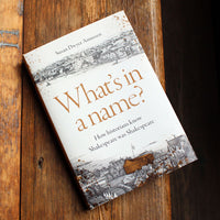 Book titled 'What's in a Name?' by Susan Dwyer Amussen on a wooden surface