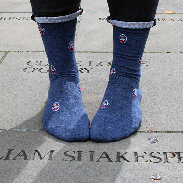 Mid blue socks with a repeating pattern of a portrait of William Shakespeare in a white oval.