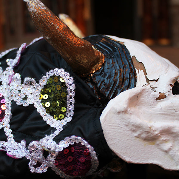 Close-up of a decorative object with a sequined heart and a textured surface.