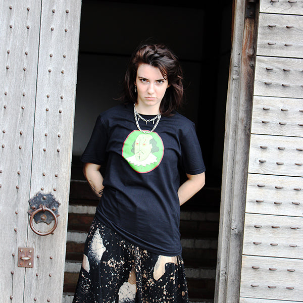 Black cotton t-shirt with a round neck and a print of a zombified Shakespeare on a green oval