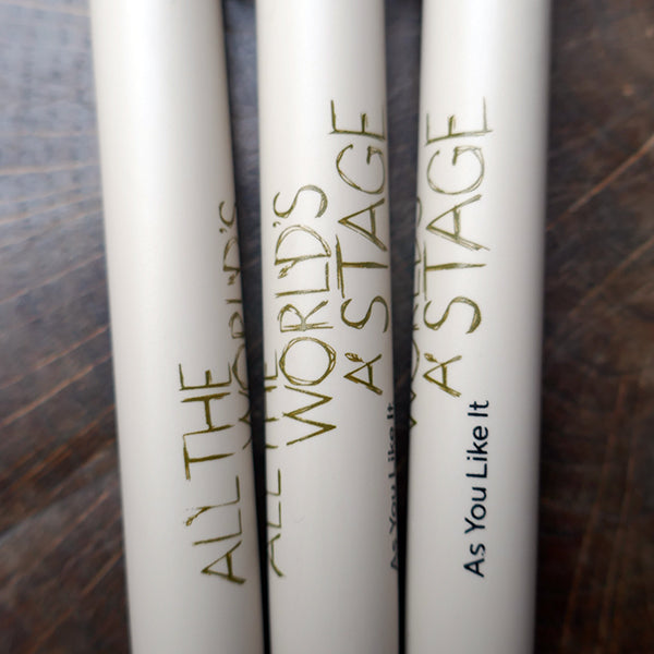 Light grey bioplastic ballpoint pen printed on the barrel with a quote from Shakespeare play, As You Like It, "All the world's a stage" in sage green hand-drawn lettering