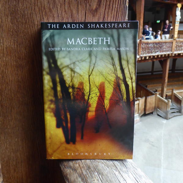 Yellow moody woodland scene with three shadowy figures on the cover of a paperback