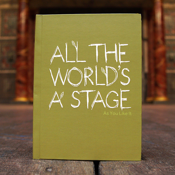 Sage green hardback journal with a quote from Shakespeare play, As You Like It (All the world's a stage) printed in white on the cover. The lettering is hand-drawn in a scribble style and has small lime green leaves growing out of it.