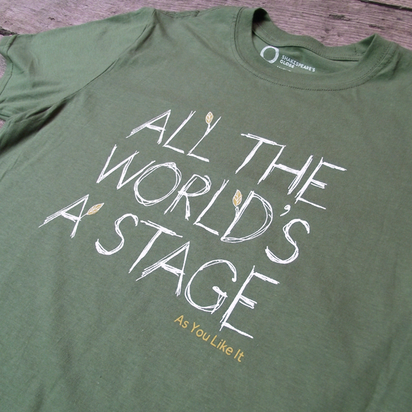 
                  
                    Sage green t-shirt with a round neckline. The t-shirt has a quote from Shakespeare play, As You Like It (all the world's a stage) printed in white centrally on the chest. The lettering is hand-drawn in a scribbled style to represent woodgrain and several of the lettering have lime green leaves growing out of them. The title of the play is printed in lime green under the quote.
                  
                