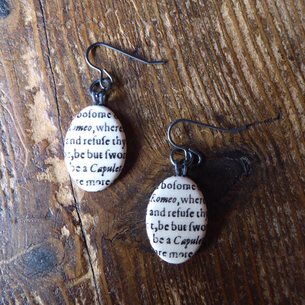 
                      
                        Oval ceramic earrings featuring a snippet from Juliet's balcony speech in Romeo and Juliet
                      
                    