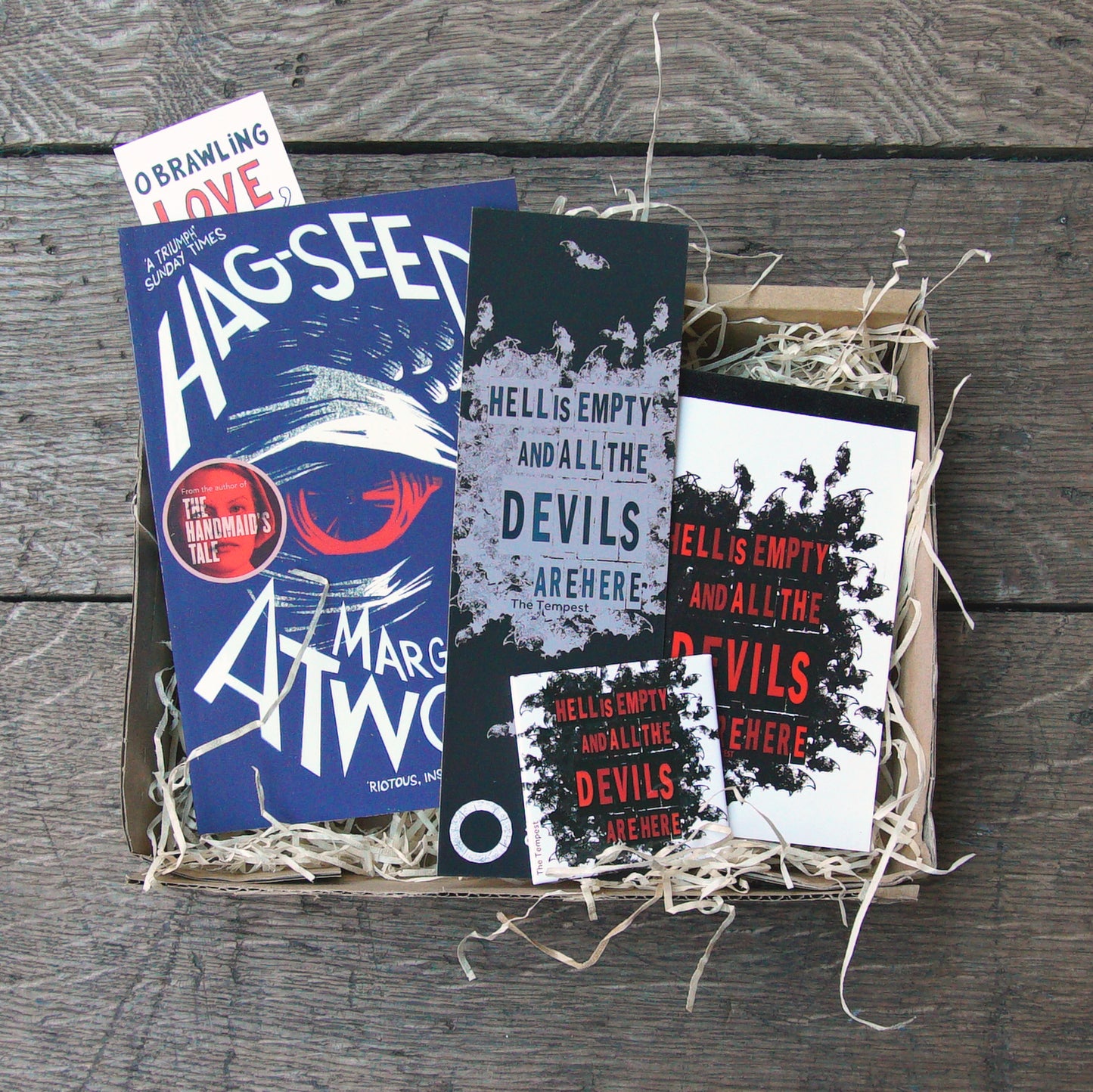 
                  
                    The Shakespeare's Globe Book Box containing a copy of Hagseed by Margaret Atwood, a large bookmark and an A6 notepad and magnet printed with a quote from The Tempest.
                  
                