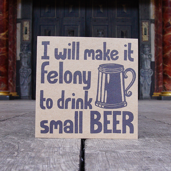 Greetings card made of brown kraft card with a lino-cut print in black. The print is a quote from Shakespeare play, Henry Iv, part 2 (I will make it felony to drink small beer) formed of hand-drawn lower case letters. Alongside the quote is a representation of a tankard.