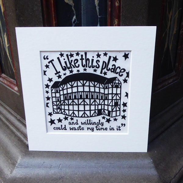 Mounted black and white lino print of the Globe Theatre surrounded by stars and a quote from Shakespeare play, As You Like It (I like this place and willingly could waste my time in it)