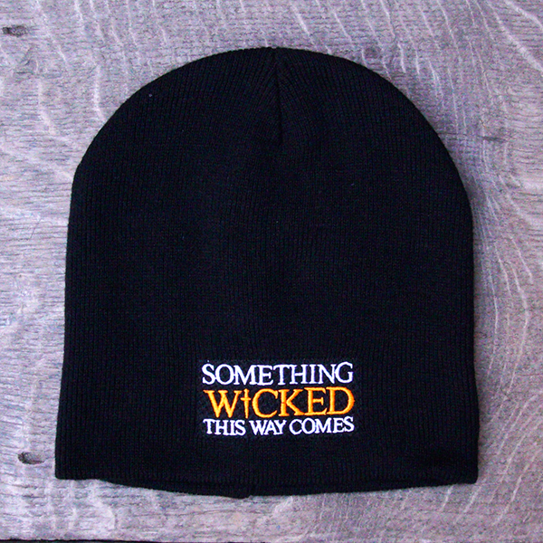 
                      
                        Black beanie hat with an embroidered quote on the front from Shakespeare play, Macbeth, "something wicked this way comes." The quote is in white capital letters with the word 'wicked' in bright orange capital letters.
                      
                    