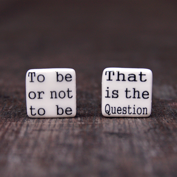 Square ceramic cufflinks made of creamy white glazed earthenware. Each cufflink has part of a quote from Shakespeare play, Hamlet in black in a simple serif font. One cufflink says 