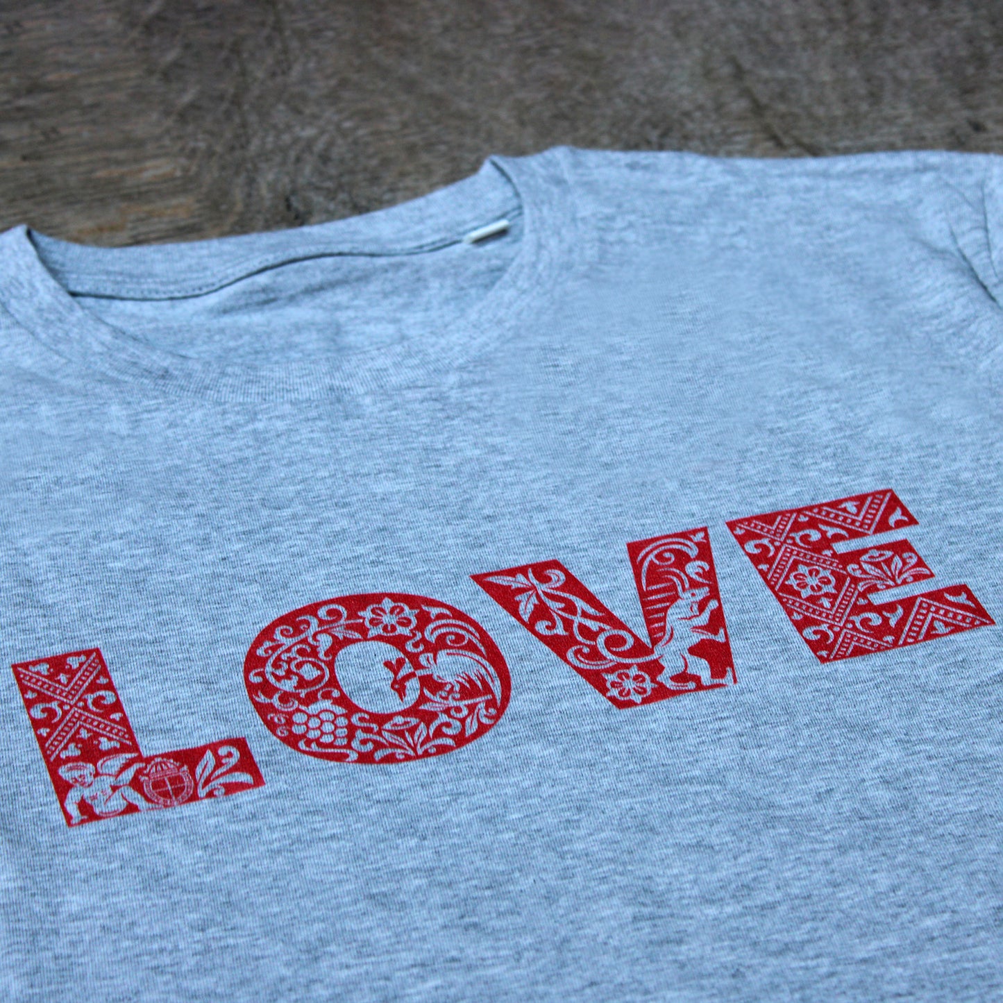 
                  
                    Grey heathered unisex tshirt with bold red graphic text across chest depicting LOVE
                  
                