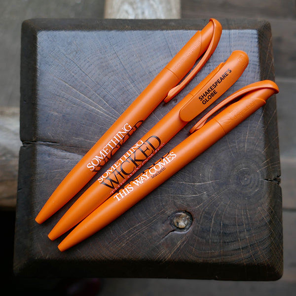 
                  
                    Orange bioplastic ballpoint pen printed on the barrel with a quote from Shakespeare play, Macbeth, "Something wicked this way comes", in black and white lettering
                  
                
