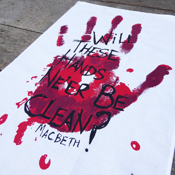 
                  
                    White cotton tea towel printed with a large bloody hand-print in reds. Over the hand-print, printed in black is a quote from Shakespeare play, Macbeth (Will these hands ne'er be clean?) The lettering is in an angry, hand-drawn style.
                  
                