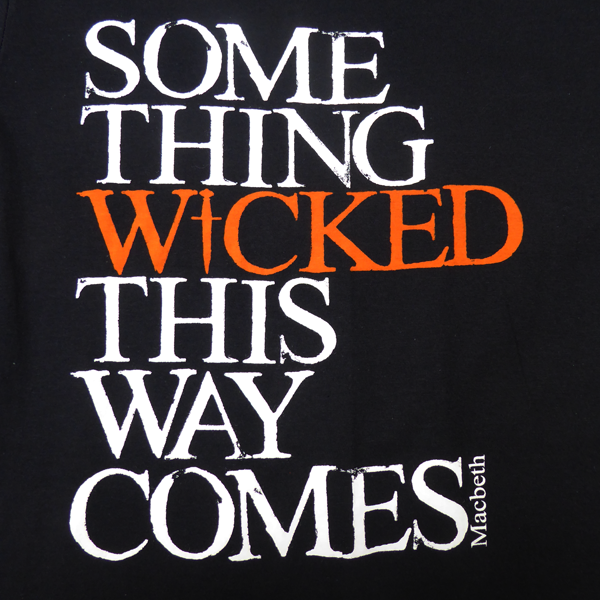 
                  
                    Black cotton crew neck, short sleeve t-shirt with a quote from Shakespeare play, Macbeth printed on the chest. The quote is printed in white, slightly distressed capital letters with the word 'wicked' printed in bright orange.
                  
                
