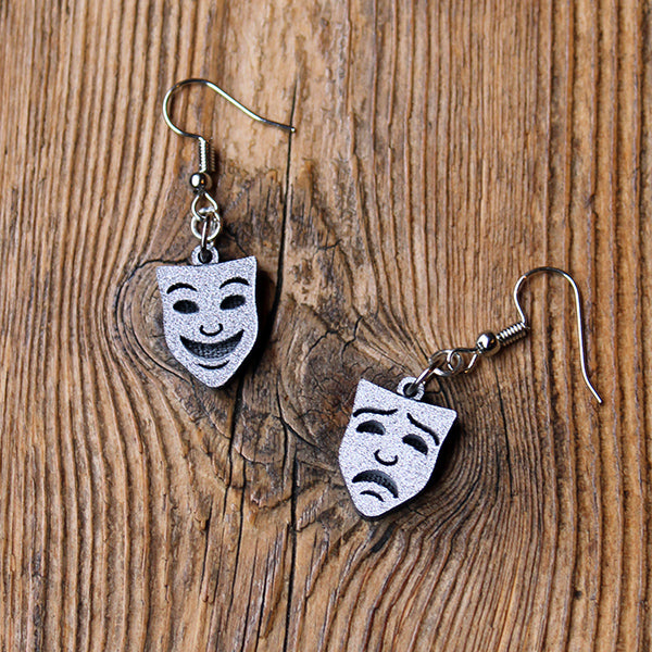 Silver resin mask earrings, comedy and tragedy faces sitting on wooden background
