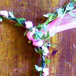 
                  
                    Wire and paper flower crown. Wire wrapped in green paper leaves and pink paper flowers. Finished with matching ribbon. 
                  
                